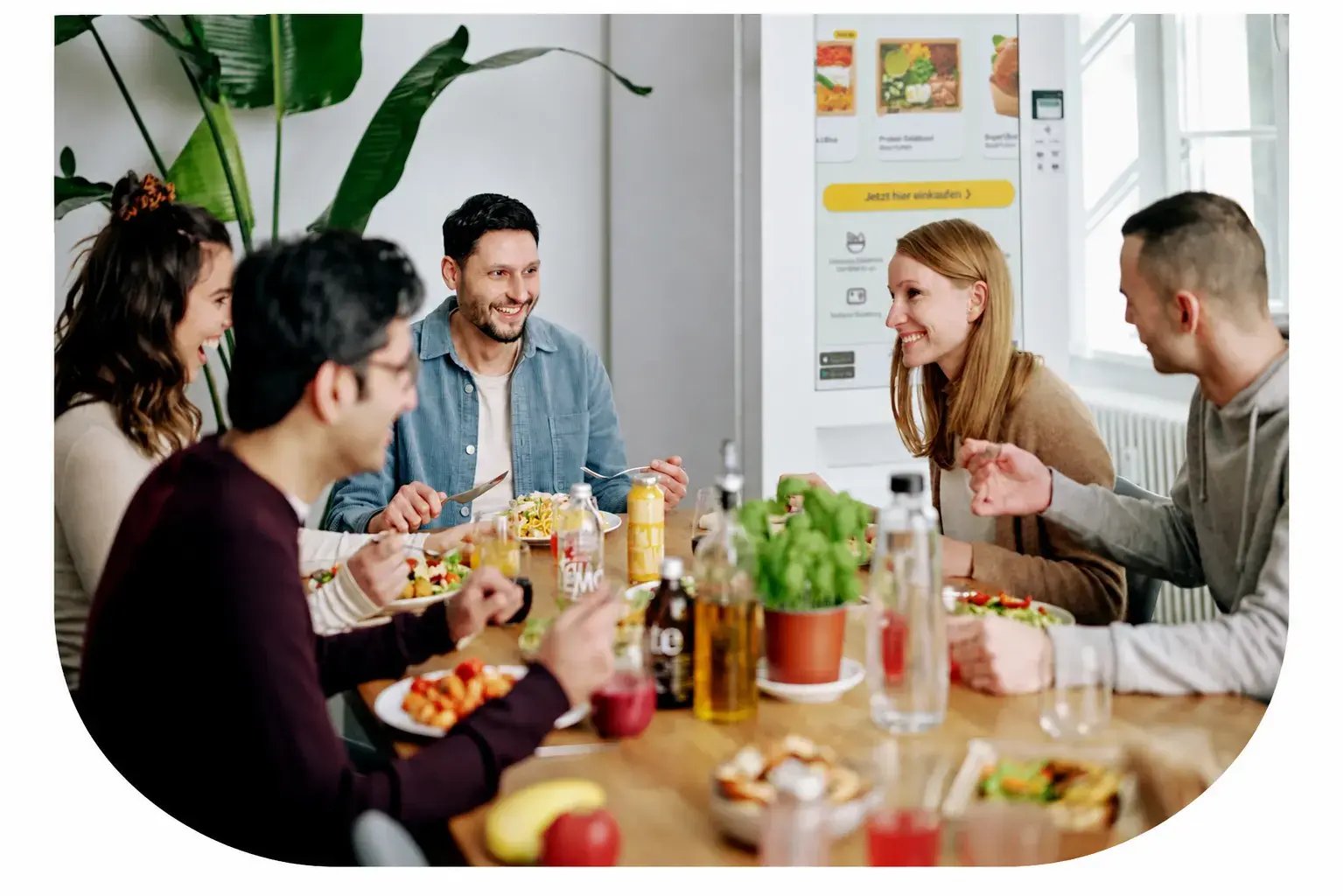 Mitarbeitende wählen gemeinsam frische Mahlzeiten am Foodji im Büro aus